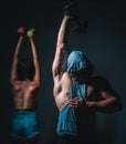 Brutal couple exercising with dumbbells together. Sexy strong fit body. Couple training with dumbbell.