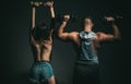 Brutal couple exercising with dumbbells together. Sexy strong fit body. Muscular man with naked body, fitness woman with