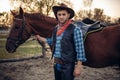 Brutal cowboy poses with horse, wild west