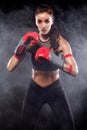 A strong athletic, woman boxer, boxing at training on the black background. Sport boxing Concept. Royalty Free Stock Photo
