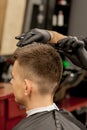Brutal guy in modern Barber Shop. Hairdresser makes hairstyle a man . Master hairdresser does hairstyle with hair clipper. Concept Royalty Free Stock Photo