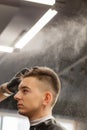 Brutal guy in modern Barber Shop. Hairdresser makes hairstyle a man . Master hairdresser does hairstyle with hair clipper. Concept Royalty Free Stock Photo