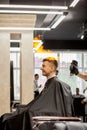 Brutal guy in modern Barber Shop. Hairdresser makes hairstyle a man . Master hairdresser does hairstyle with hair clipper. Concept Royalty Free Stock Photo