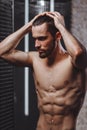 Brutal man with abs is relaxing tight musculars under the shower Royalty Free Stock Photo