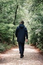 A brutal man in black clothes walks down the alley, back view Royalty Free Stock Photo