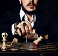 Brutal man in black suit and stylish rings playing chess with bottle of perfume, making a move, attack white queen Royalty Free Stock Photo