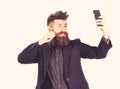 Brutal man with cheerful face. Bearded man smiles and makes self portrait. Hipster with long beard and happy face