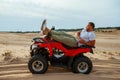 Brutal man lying on atv in desert, side view Royalty Free Stock Photo