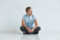 Brutal man in a shirt with short sleeves sitting in lotus posture, Royalty Free Stock Photo