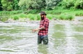 Brutal man wear rubber boots stand in river water. Satisfied fisher. Fishing requires you to be mindful and fully Royalty Free Stock Photo