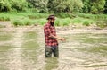 Brutal man wear rubber boots stand in river water. Satisfied fisher. Fishing requires you to be mindful and fully Royalty Free Stock Photo