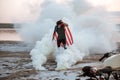 Brutal man wearing usa flag cape posing in white smoke Royalty Free Stock Photo