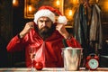 Brutal masculine bearded Santa man with clock and champagne getting resdy to meet New Year. Beautiful Christmas