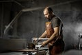 Brutal master carpenter saws wood blanks on machine in workshop