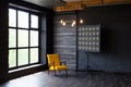 Brutal modern interior in a dark color with a yellow leather chair and big window. Loft style living room