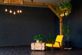 Brutal modern interior in a dark color with a yellow leather chair. Loft style living room