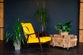 Brutal modern interior in a dark color with a yellow leather chair. Loft style living room