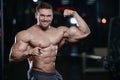 Brutal strong bodybuilder athletic men pumping up muscles with d