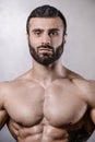 Brutal strong bodybuilder man posing in studio on grey background. Royalty Free Stock Photo