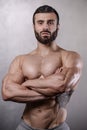 Brutal strong bodybuilder man posing in studio on grey background. Royalty Free Stock Photo