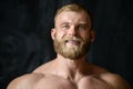 Brutal strong bodybuilder man posing in studio on grey background. Royalty Free Stock Photo