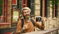 Brutal stylish man with retro camera. Modern business. Old technology. Professional photographer use vintage camera Royalty Free Stock Photo