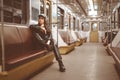 Brutal Woman in a Leather Jacket, Leather Pants and Ankle Boots Sits Alone in a Train Car. Toned Picture. Close-up