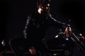 Brutality and masculine concept. Man with beard, biker in leather jacket lean on motor bike in darkness, black