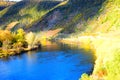 Bruttig-Fankel, Germany - 11 12 2020: blue Mosel and steep yellow vineyards in autumn sun Royalty Free Stock Photo
