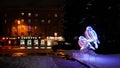 Bryansk, Russia - December 7, 2021: evening city square with glowing Christmas figures in the form of bullfinch birds on the backg