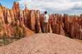 Bryce Canyon - Man with scenic aerial view of hoodoo sandstone rock formations on Queens Garden trail in Utah, USA