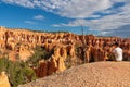 Bryce Canyon - Man sitting on hill with scenic aerial view of hoodoo sandstone rock formations on Queens Garden trail, Utah, USA Royalty Free Stock Photo