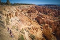 Bryce Canyon with red hoodoo rock formations viewed from above with hikers wandering around the bottom