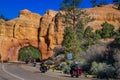 BRYCE CANYON, UTAH, JUNE, 07, 2018: Outdoor view of motorcyclists in the road crossing throught the red arch road tunnel