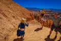 BRYCE CANYON, UTAH, JUNE, 07, 2018: Young Travelers taking pictures and standing on the cliff of Bryce Canyon National