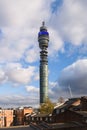 BT Tower rising against blue sky with partially cloudy sky over buildings