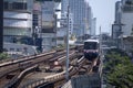 BTS Sky Train is running in downtown pass through skycrapers business building in Bangkok