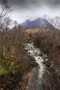 Buachaille Etiuve mor Mountain seen in the background with a fast moving stream with white water in the foreground.