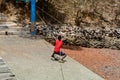 Unidentified local boy in red shirt pulls the rope in a village