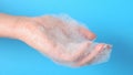 Bubble bath foam in woman\'s hands. Closeup woman\'s hand washing with soap on a blue background ,Practice good Royalty Free Stock Photo