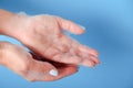 Bubble bath foam in woman's hands. Closeup woman's hand washing with soap on a blue background , selective focus. Royalty Free Stock Photo