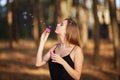 Portrait of pretty woman with bubbles, traveler relaxing in forest.