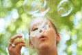 Bubble-blowing blonde. a young woman blowing bubbles outside. Royalty Free Stock Photo