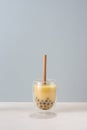 Bubble boba tea with milk and tapioca pearls in glass on blue background Royalty Free Stock Photo