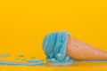 Bubble gum ice cream in a traditional cone on a yellow background. Melting with scattered drops Royalty Free Stock Photo