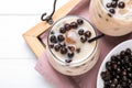 Bubble milk tea with tapioca balls on white wooden table, top view