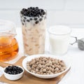 Bubble milk tea with tapioca pearl topping ingredient, famous Taiwanese drink on white wooden table