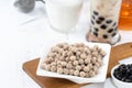 Bubble milk tea with tapioca pearl topping ingredient, famous Taiwanese drink on white wooden table