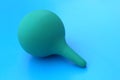 A green pear lies on a blue background.