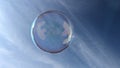 A bubble reflecting light floating in a blue sky Royalty Free Stock Photo